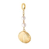 Pearlescent shell charm in yellow gold from Dorne, capturing coastal elegance and natural boho charm.